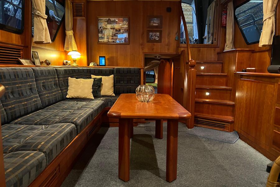 Altena Look 2000 - Salon met zithoek, tafel, trap naar stuurhut