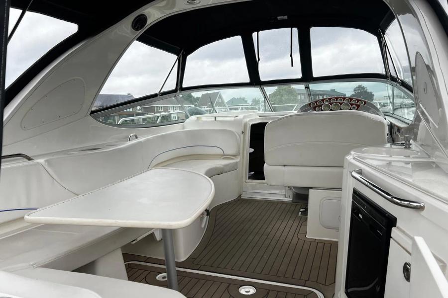 Bayliner 320 - stuurhut met dashboard, zithoek, tafel, koelkast