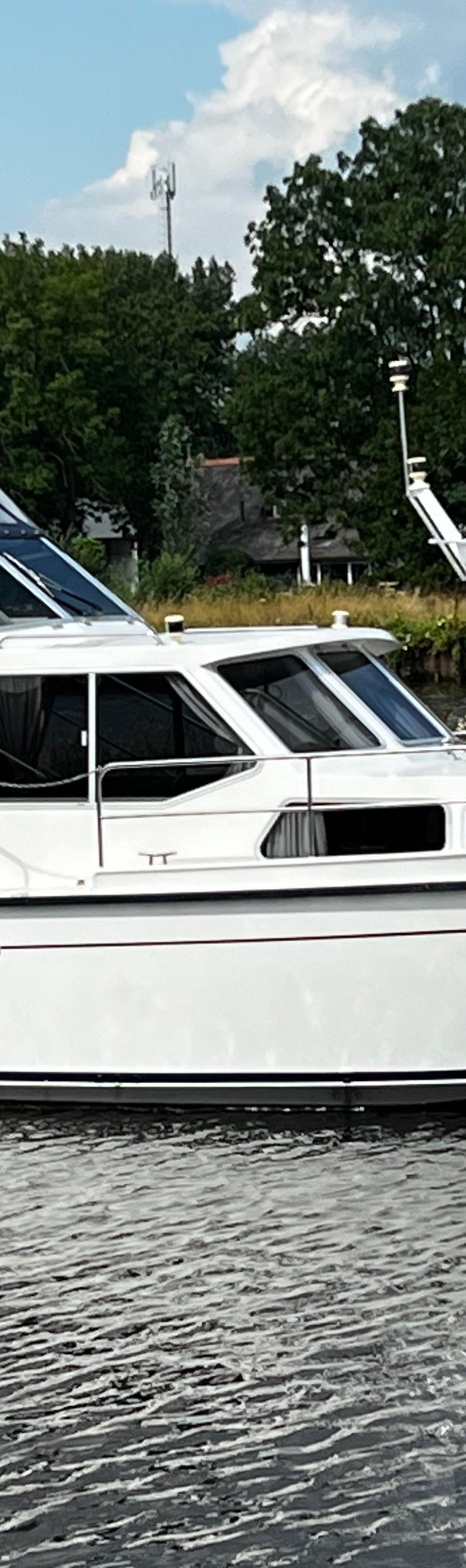 Boarncruiser 1000 - Aanzicht boot van stuurboord met kap en mast