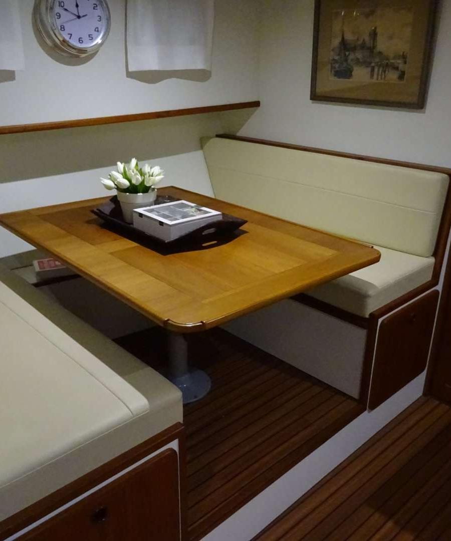 Luxe dinette met houten tafel en lichte banken.