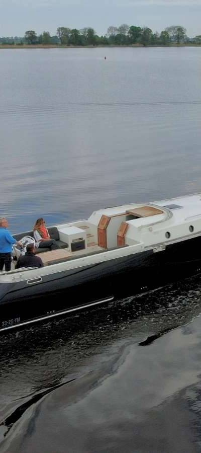 Gulliver 1220 - Achtersteven van de boot met mensen aan boord op water