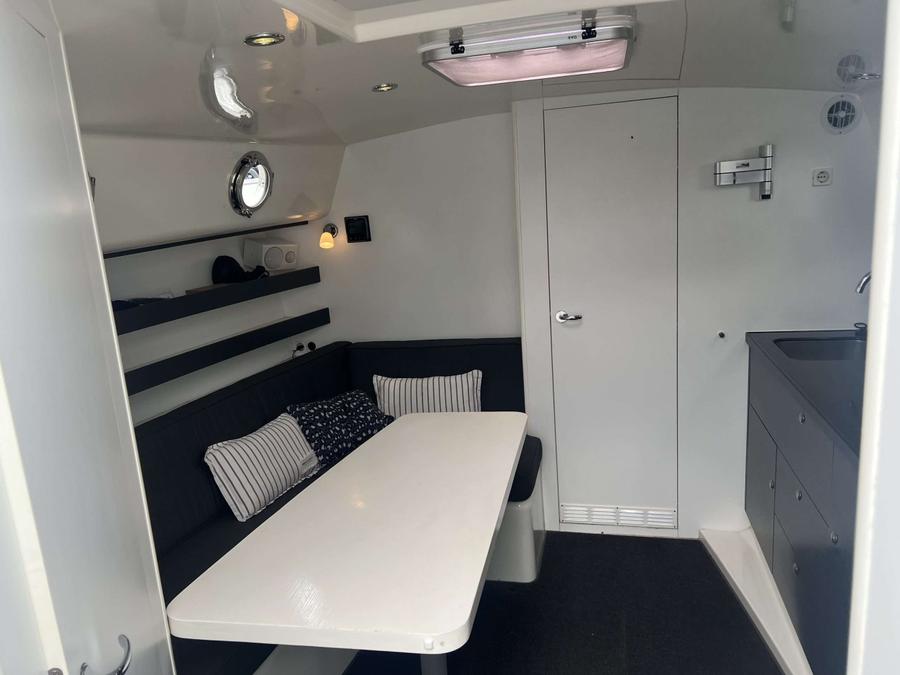 Gulliver 1220 - kajuit met zithoek, tafel, en kombuis met spoelbak