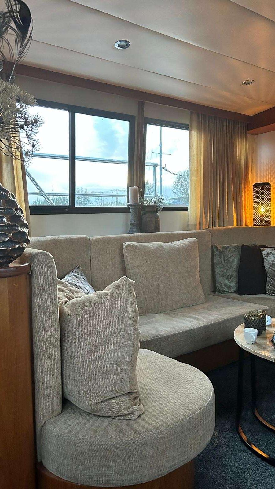 Salon met zithoek, tafel, en ramen met gordijnen