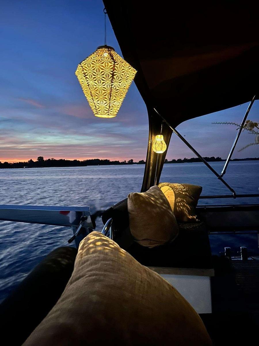 Kuip met kussens, sfeerverlichting en uitzicht op water