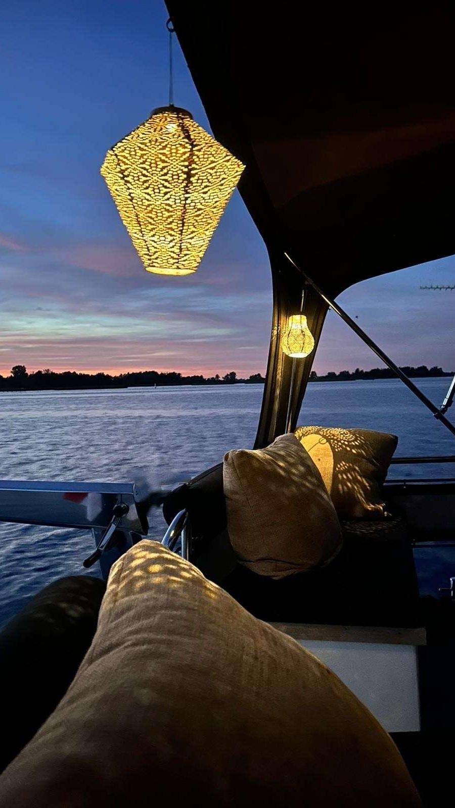 Kuip met kussens, sfeerverlichting en uitzicht op water