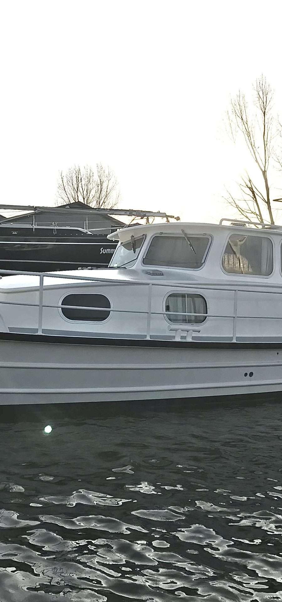 Voormalige Patrouilleboot - Zijaanzicht witte stalen motorboot in het water
